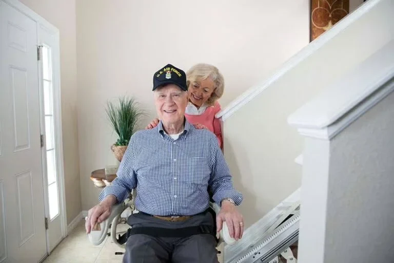 A couple together beside a Nautilus stair lift in their home